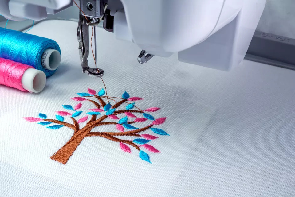creating embroidery on white fabric with embroidery machine
